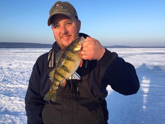 Dave holding a jumbo perch on the ice