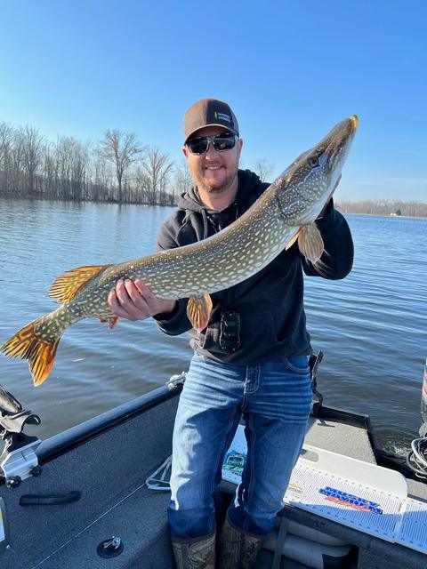 Dave holding a northern pike on a boat