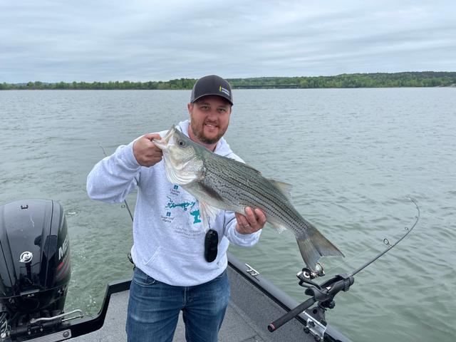 Dave holding a striped bass on a boat